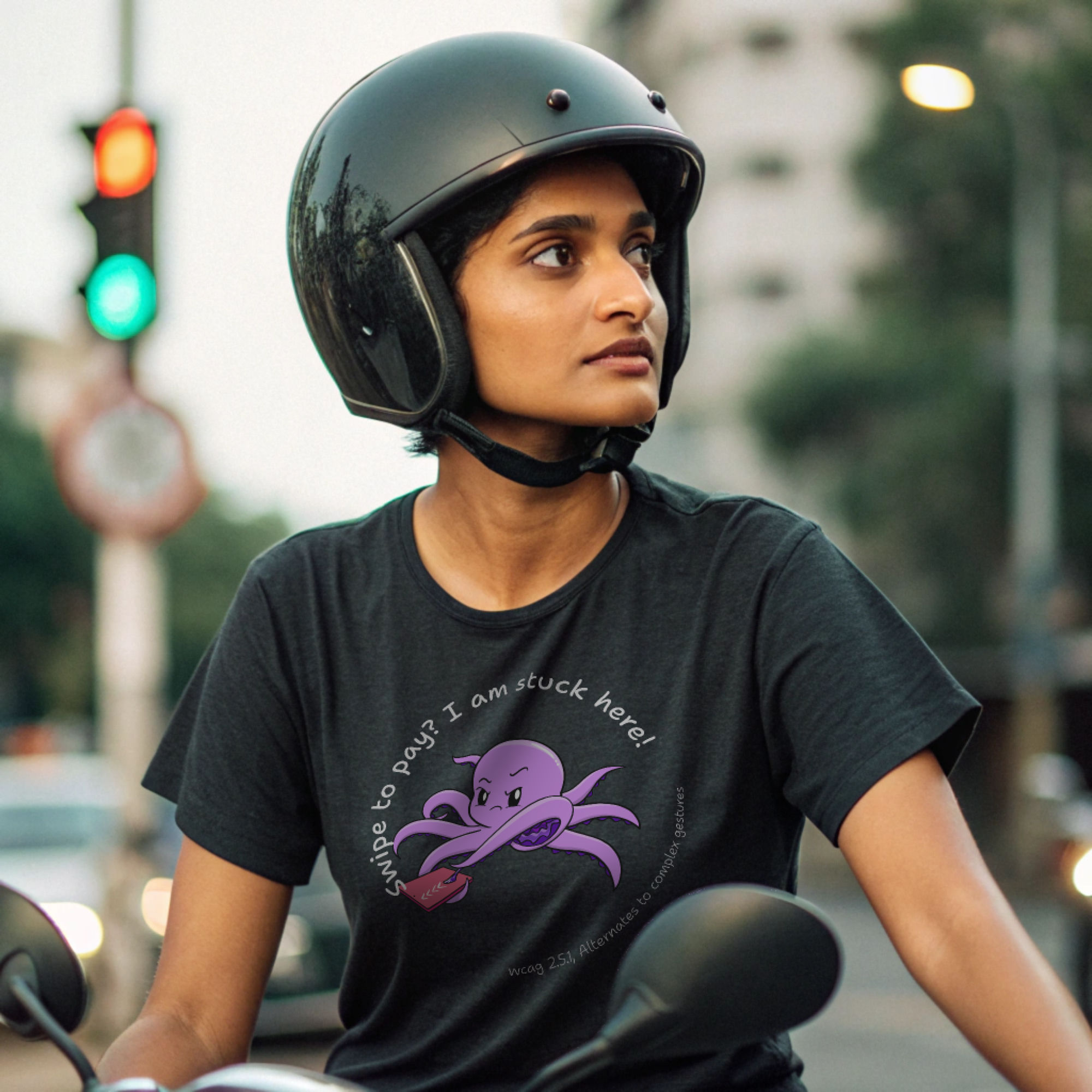 Person on a scooter wearing a black t-shirt with a cartoon octopus and the text 'Swipe to pay? I am stuck here!' referencing WCAG 2.5.1